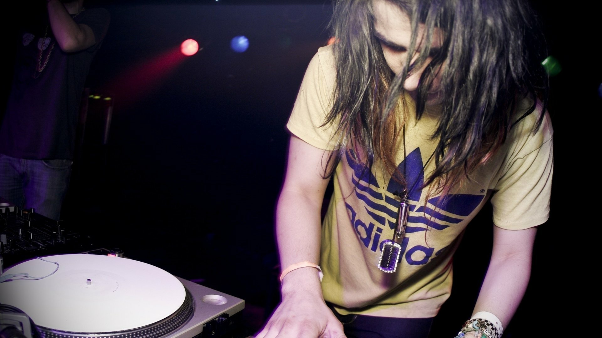 HD desktop wallpaper featuring Skrillex performing live, immersed in music with dynamic stage lighting.