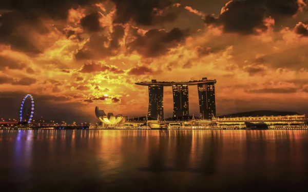 Sunset over Singapore's Marina Bay Sands and ArtScience Museum, golden clouds mirrored in the bay — HD PC desktop wallpaper of a man-made waterfront skyline.