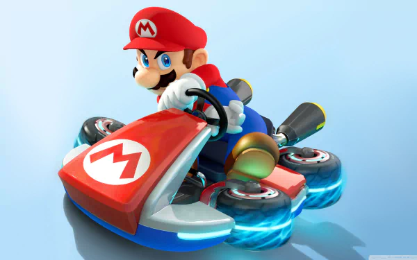 A colorful HD desktop wallpaper featuring Mario racing in Mario Kart 8, showcasing his iconic red hat and go-kart with glowing wheels against a light blue background.