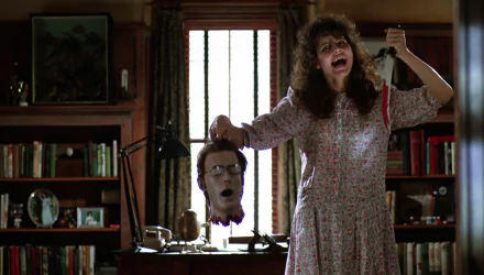 HD PC desktop wallpaper featuring a scene from the movie Beetlejuice, showing a woman holding a severed head in a dimly lit room.