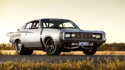 HD PC desktop wallpaper featuring a classic silver Dodge Charger, resembling a Chrysler Valiant Charger, set against a clear sky and natural landscape background.