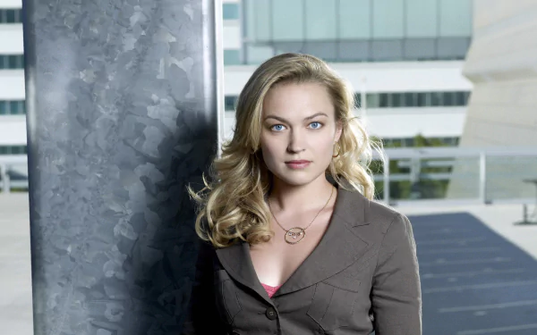 Sophia Myles poses confidently against a modern backdrop, showcasing her elegance. This HD desktop wallpaper captures the actress in a stylish, professional look.