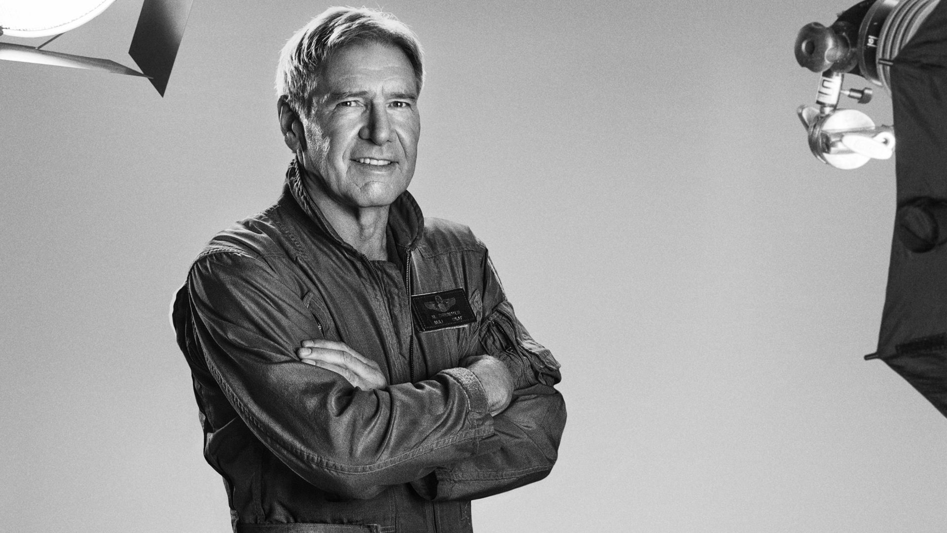 Black and white HD desktop wallpaper featuring Harrison Ford as Max Drummer from the movie The Expendables 3, standing confidently with arms crossed in a studio setting.