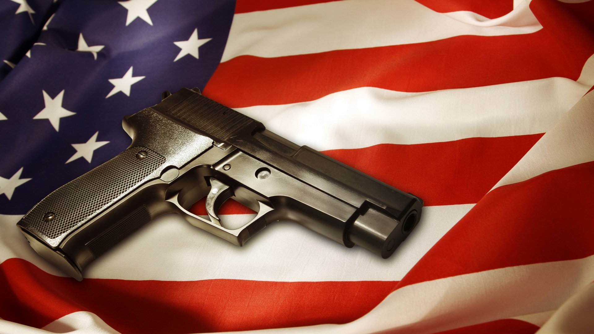 A detailed 4K Ultra HD wallpaper featuring a pistol resting on an American flag, combining elements of man-made craftsmanship and patriotic symbolism.