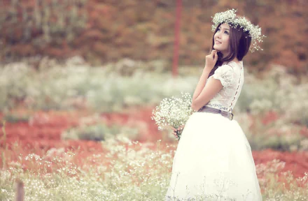 HD PC desktop wallpaper and background: a bride in a white dress and flower crown, holding a bouquet in a soft-focus wildflower field.