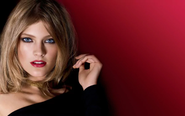 HD PC desktop wallpaper featuring French model Constance Jablonski with blue eyes, blonde hair, and a red background.