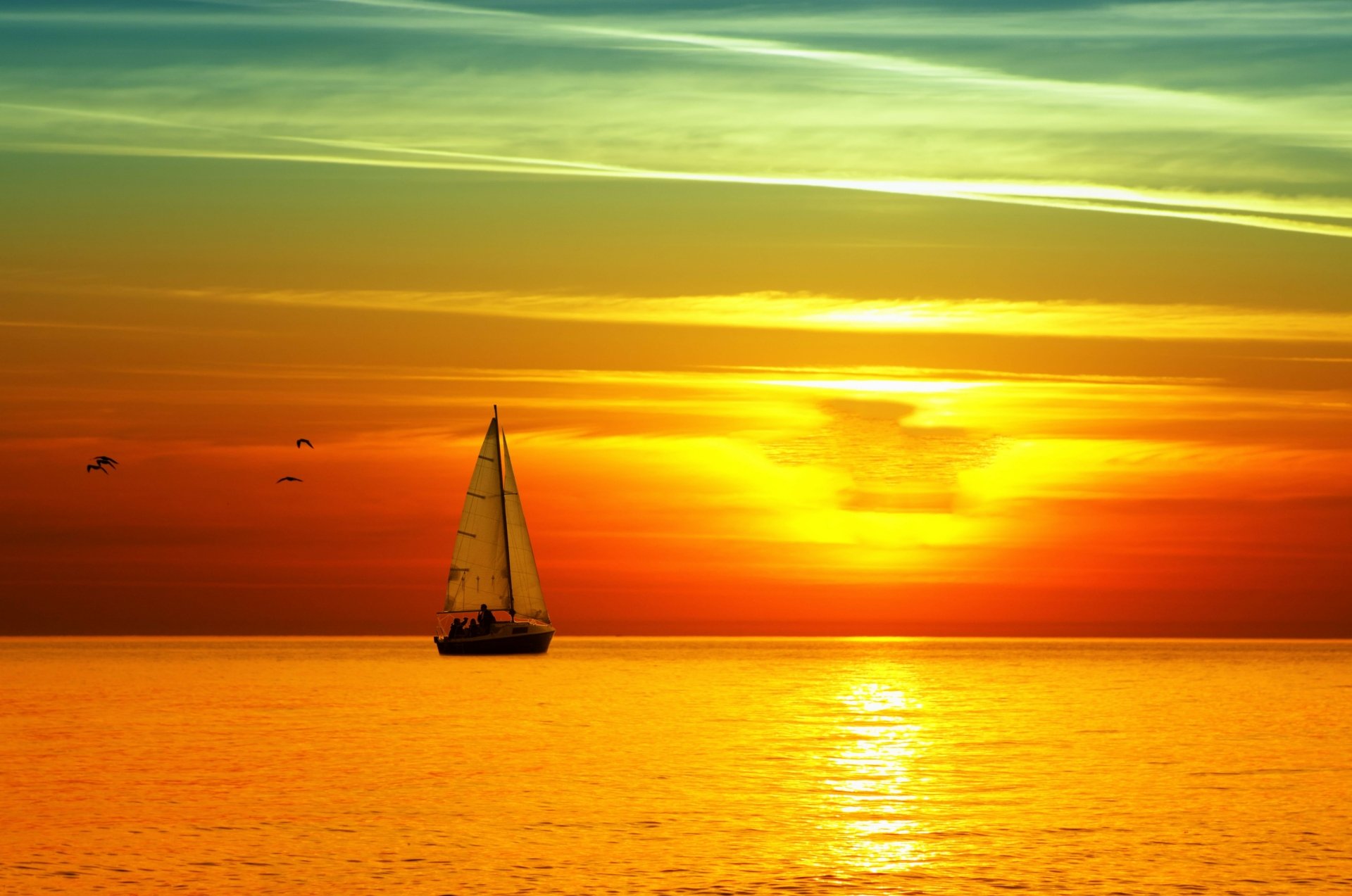 A serene sunset over the sea, featuring a sailboat gliding across the water. Vibrant hues of orange and yellow create a stunning 4K Ultra HD desktop wallpaper.