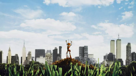 HD PC desktop wallpaper from the movie Antz: a lone ant stands triumphantly on a dirt mound amid tall grass, with a city skyscraper skyline and bright blue sky behind.