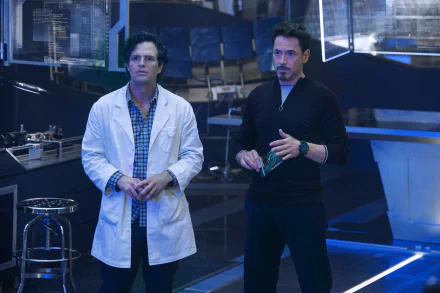 Tony Stark and Bruce Banner, portrayed by Robert Downey Jr. and Mark Ruffalo, stand together in a scene from Avengers: Age of Ultron, set against a high-tech background.