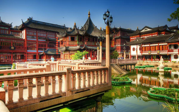 HD desktop wallpaper showcasing the ornate Tea Palace in Shanghai, China, featuring traditional architecture and a serene pond surrounded by man-made structures.