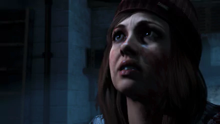 HD PC desktop wallpaper/background: a blood-smudged young woman in a beanie from the video game Until Dawn, gazing upward in dim, icy surroundings.