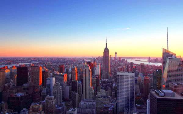HD desktop wallpaper showing a vibrant New York City skyline at sunset, highlighting iconic man-made skyscrapers under a clear sky.