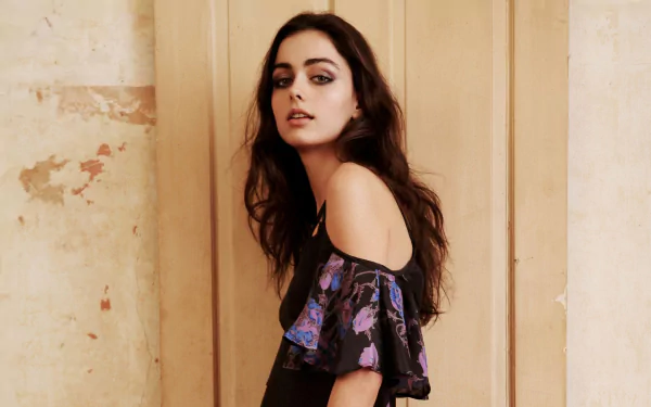 HD desktop wallpaper featuring brunette model Darla Baker with loose hair, wearing an off-shoulder floral top against a neutral textured background.