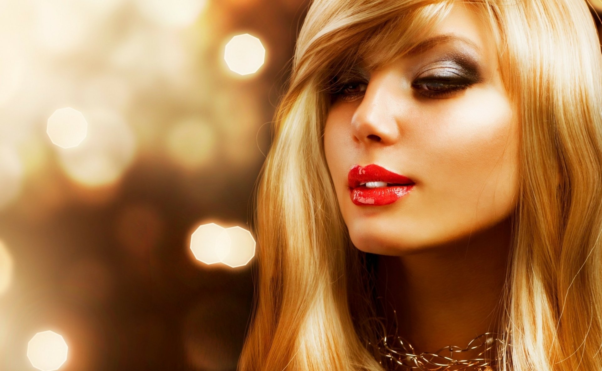 Glamorous blonde woman with smoky eyes and red lips against a warm gold bokeh background — HD PC desktop wallpaper.