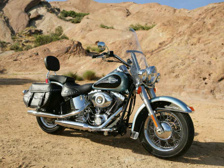 Harley-Davidson Heritage Softail motorcycle bike vehicle with chrome accents and leather saddlebags parked by rocky desert hills, HD desktop wallpaper.