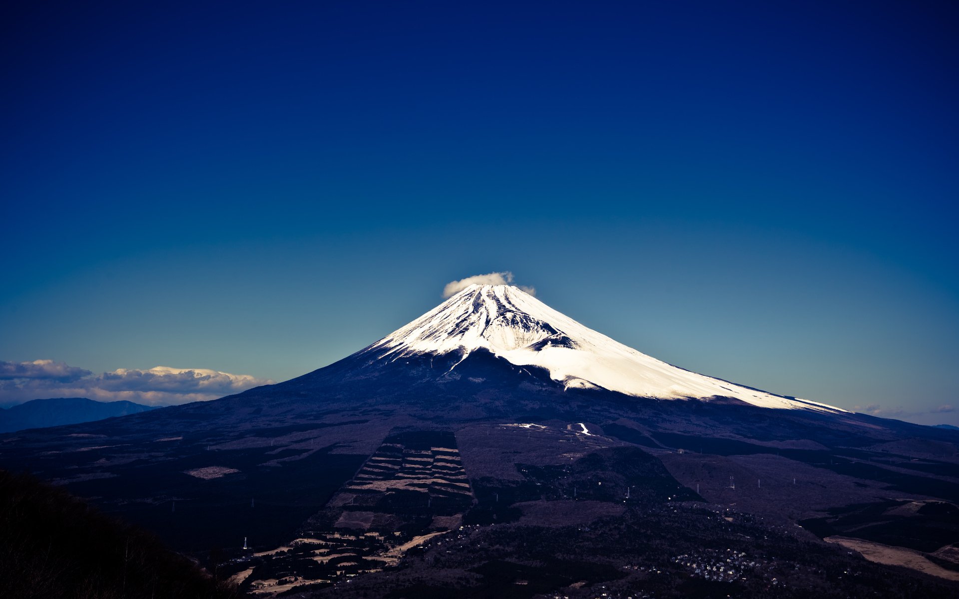HD PC desktop wallpaper/background: nature scene of a snow-capped volcano rising under a deep blue sky with distant clouds.
