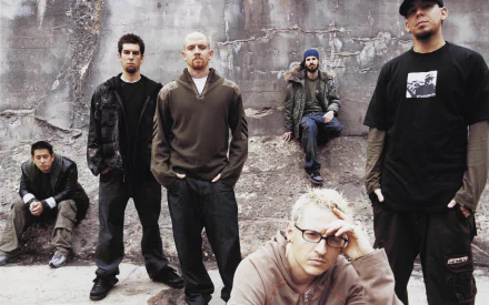 High-definition desktop wallpaper featuring the band Linkin Park, showcasing the members posed against a rugged wall, capturing their iconic style and musical energy.
