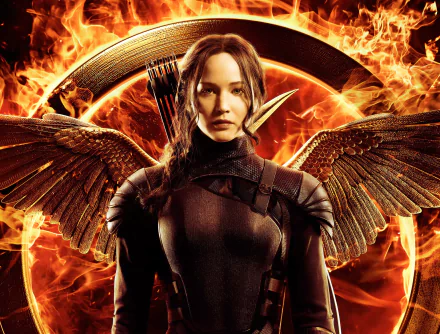 HD desktop wallpaper featuring Katniss Everdeen (Jennifer Lawrence) from The Hunger Games: Mockingjay - Part 1, with flaming wings in the background.