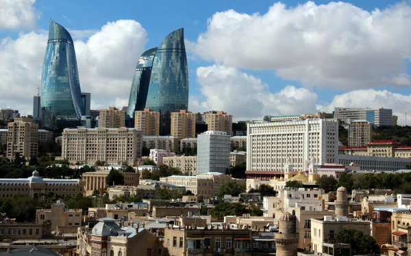 A stunning HD desktop wallpaper of Baku, Azerbaijan, showcasing the city's man-made skyline with modern skyscrapers and historic buildings under a partly cloudy sky.