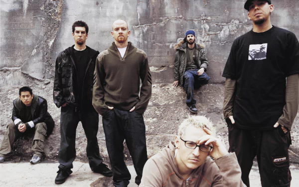 High-definition desktop wallpaper featuring the band Linkin Park, showcasing the members posed against a rugged wall, capturing their iconic style and musical energy.