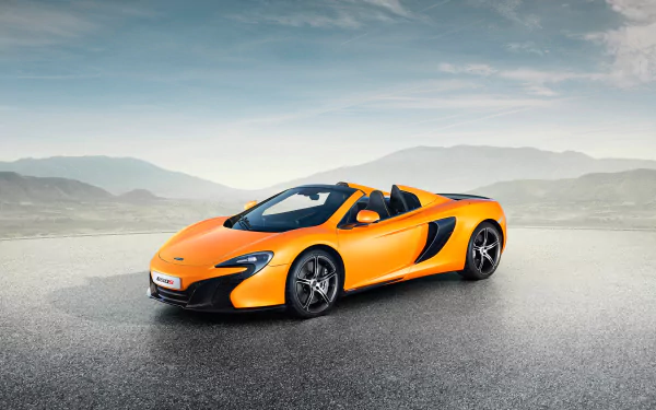 Orange McLaren 650S Spider supercar on wet asphalt with misty hills and cloudy sky — 2K Quad HD PC desktop wallpaper