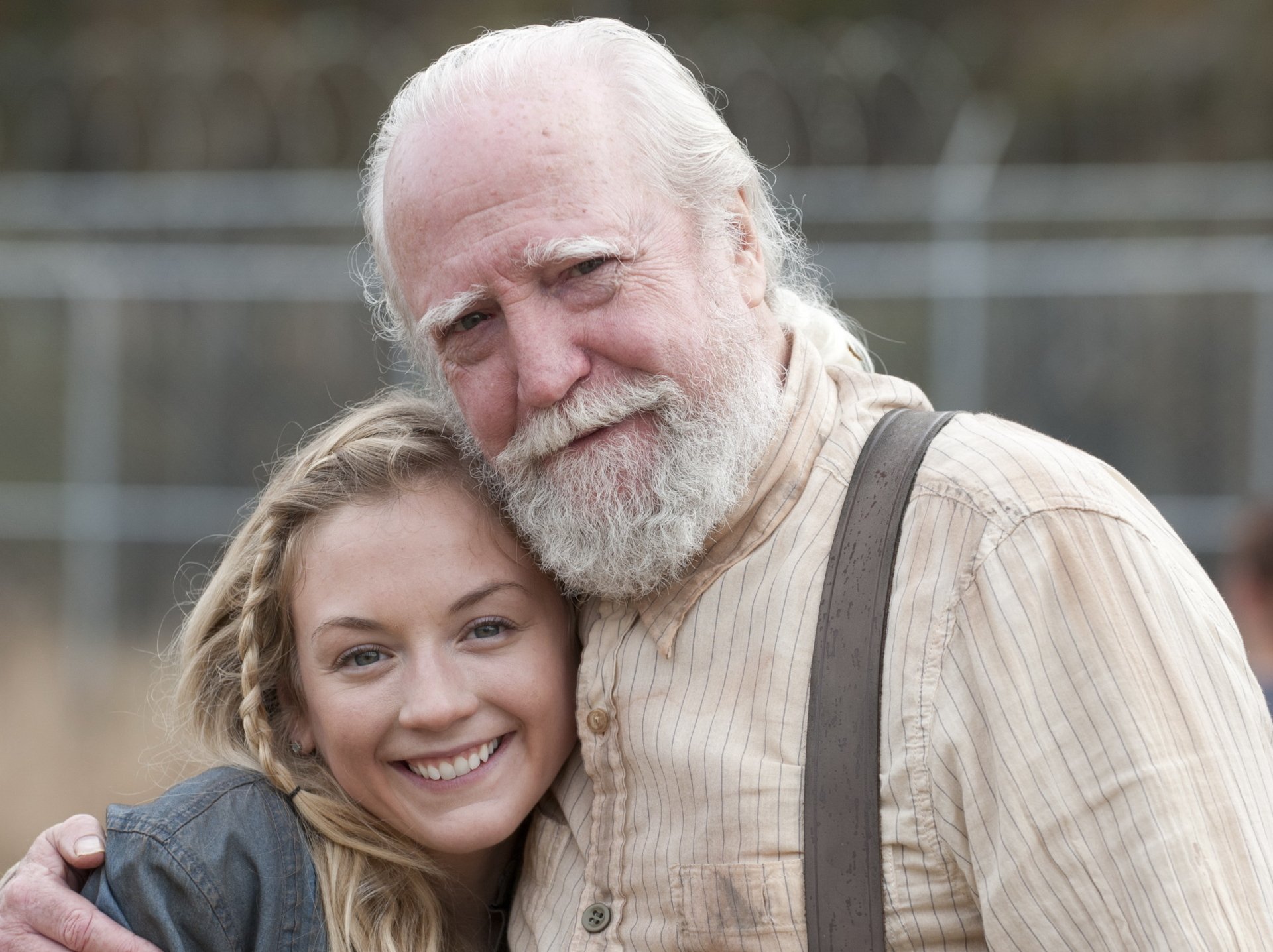 A heartwarming moment between two characters from the TV show The Walking Dead, set against a blurred background, making it a striking HD desktop wallpaper.