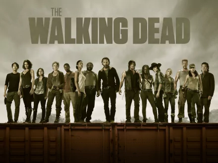 HD desktop wallpaper and background featuring the cast of the TV show The Walking Dead standing on a railway container, with a cloudy sky and the show's title in large letters above them.