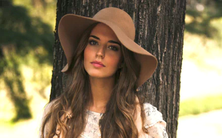HD PC desktop wallpaper featuring a woman with long hair wearing a wide-brimmed hat, standing outdoors near a tree, tagged with Clara Alonso.