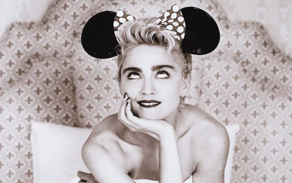 A black-and-white HD wallpaper featuring Madonna wearing a polka-dot Mickey Mouse headband, playfully posing with a thoughtful expression against a stylish backdrop.