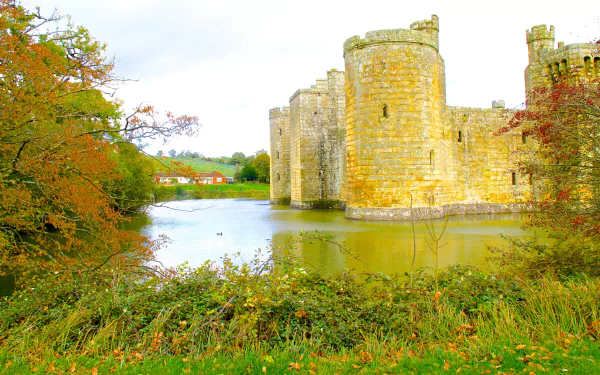 HD desktop wallpaper showing the medieval Bodiam Castle surrounded by water and autumn foliage, highlighting the historic man-made architecture.