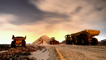 A striking 4K Ultra HD wallpaper featuring Caterpillar vehicles working on a rugged terrain, with a backdrop of a dramatic sky and a sand pile in the distance.
