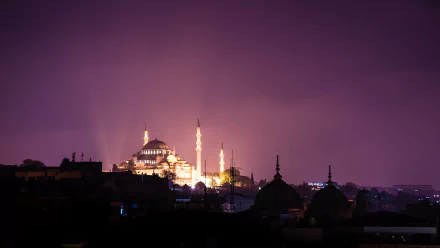 Illuminated Süleymaniye Mosque glows against a dark night sky, showcasing its stunning architecture and religious significance in Islam. A captivating HD wallpaper for any desktop.