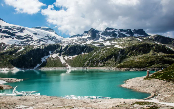 A stunning view of the Alps featuring a turquoise lake surrounded by majestic snow-capped mountains, captured in vibrant detail for a 4K Ultra HD desktop wallpaper.