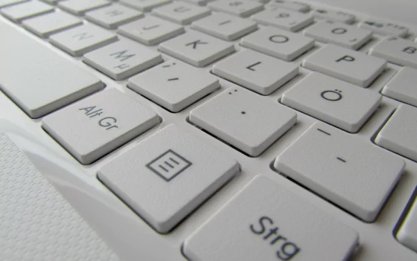 Close-up of a sleek, white keyboard, highlighting the modern design and technology aesthetic. This HD desktop wallpaper adds a tech-inspired touch to your background.