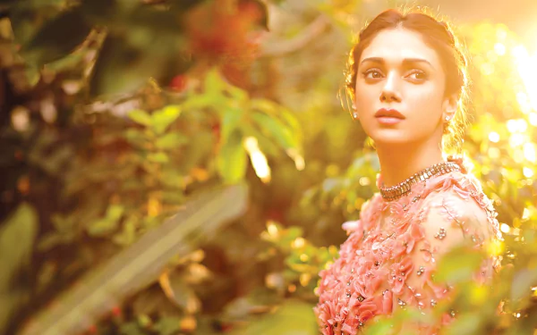 Aditi Rao Hydari bathed in warm sunshine, surrounded by lush greenery in this vibrant HD PC desktop wallpaper featuring the Indian celebrity.