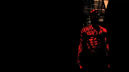 Comic Daredevil in red shadow stands by a fire escape on the right against black negative space — HD PC desktop wallpaper and background.