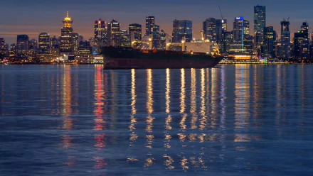 Night view of a large ship anchored in Vancouver, Canada, with city lights reflecting on the calm water in this 4K Ultra HD desktop wallpaper.