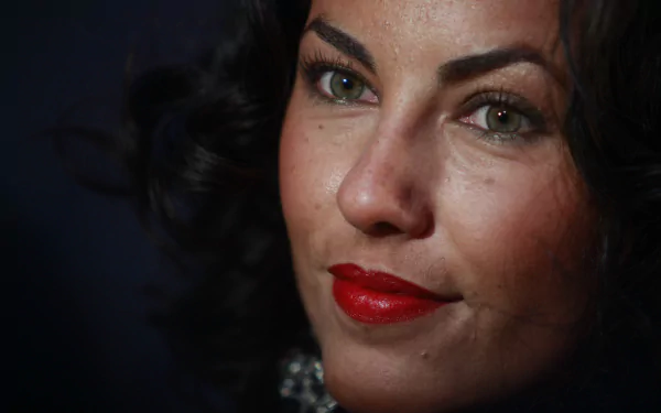 Close-up of Mexican actress Bárbara Mori, showcasing her striking features with dark, curly hair and bold red lips, set against a dark background. HD desktop wallpaper.