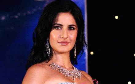 HD desktop wallpaper featuring Bollywood celebrity Katrina Kaif in an elegant attire with a sparkling necklace, set against a star-studded background.