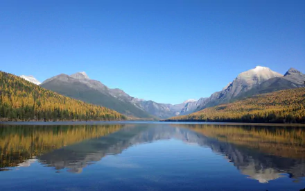 HD PC desktop wallpaper: serene mountain lake with golden trees and snow-capped peaks mirrored in glassy water, a nature reflection background.