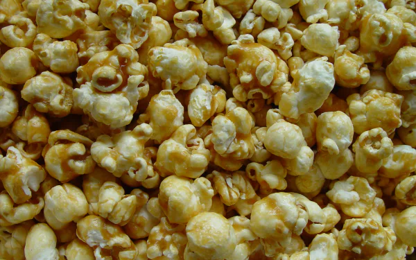 Caramel-coated popcorn dessert, golden sweet clusters filling the frame — 2K Quad HD PC desktop wallpaper and background.
