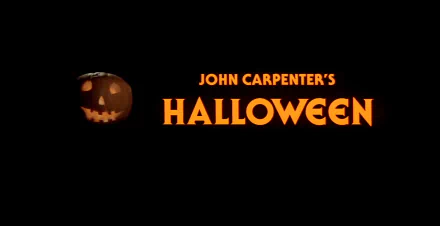 A dark background featuring the iconic title of John Carpenter's Halloween (1978) in bold orange, with a carved pumpkin on the side, creating a spooky atmosphere for a desktop wallpaper.