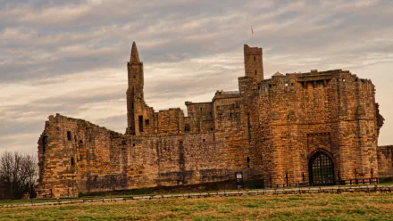 HD desktop wallpaper showcasing the man-made Warkworth Castle under a dramatic cloudy sky.