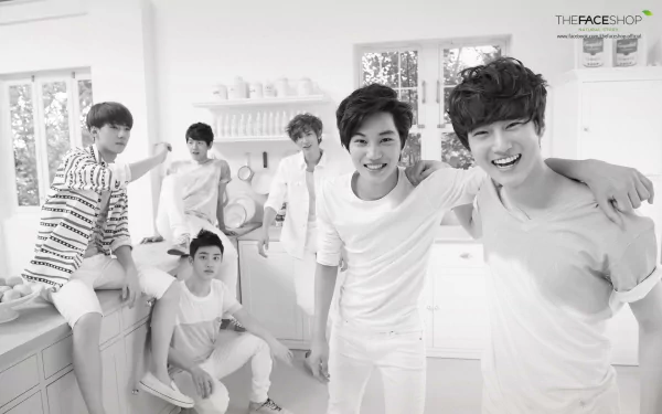 A black and white HD wallpaper featuring the K-pop group EXO, showcasing the members in a bright kitchen setting, radiating joy and camaraderie.