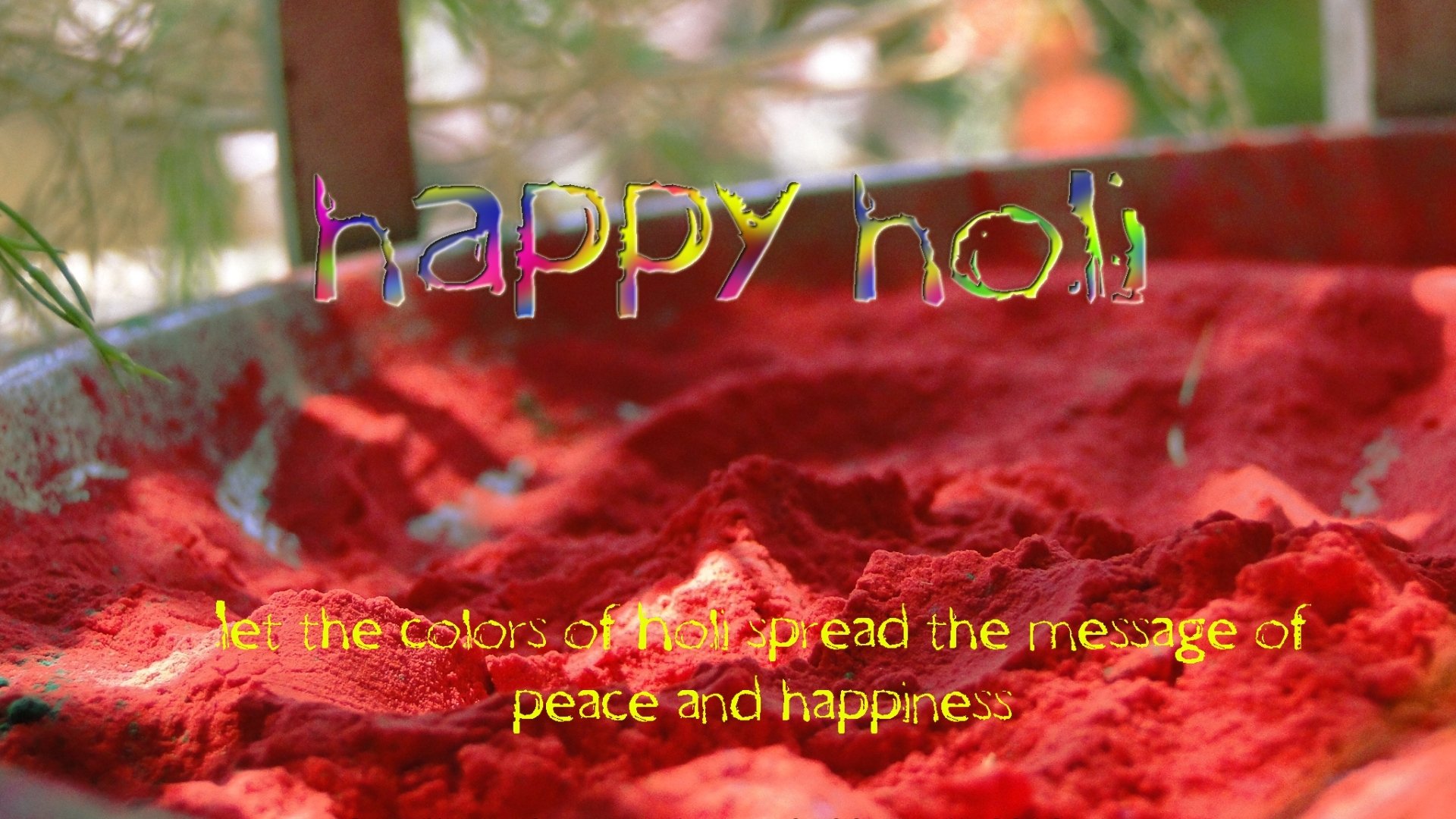 HD PC desktop wallpaper featuring vibrant red Holi colors with the text happy holi and a message of peace and happiness for the holiday celebration.