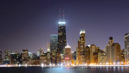 A stunning night view of Chicago’s skyline, showcasing illuminated skyscrapers reflecting on the water. This 4K Ultra HD desktop wallpaper captures the city's vibrant spirit.