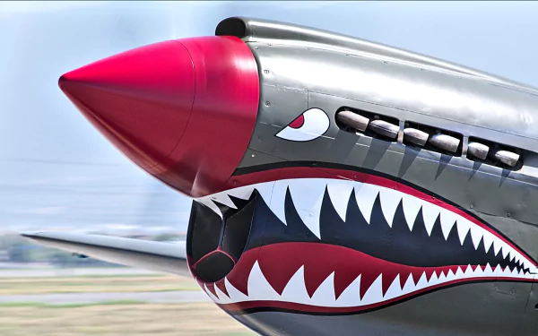 HD PC desktop wallpaper/background: military Aircraft Nose Art — close-up of a silver fighter nose with a red cone, painted eye and menacing shark-mouth teeth.