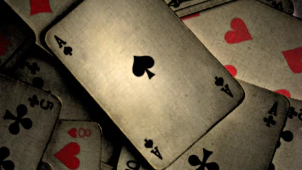 A high-definition wallpaper featuring an Ace of Spades card surrounded by various playing cards, showcasing a dramatic arrangement with contrasting colors and textures.