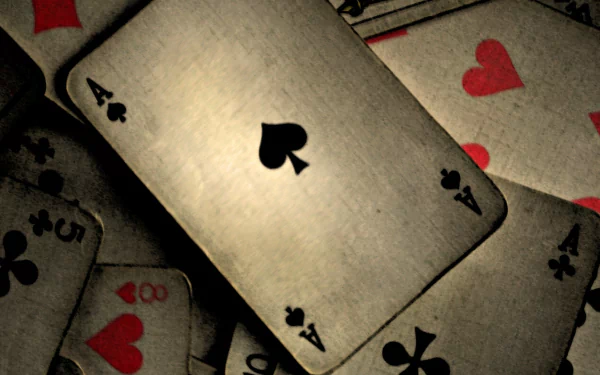 A high-definition wallpaper featuring an Ace of Spades card surrounded by various playing cards, showcasing a dramatic arrangement with contrasting colors and textures.
