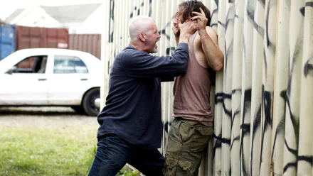 HD PC desktop wallpaper from the movie The Art Of The Steal showing a tense confrontation between two men, one pressing the other against a graffiti-covered wall.